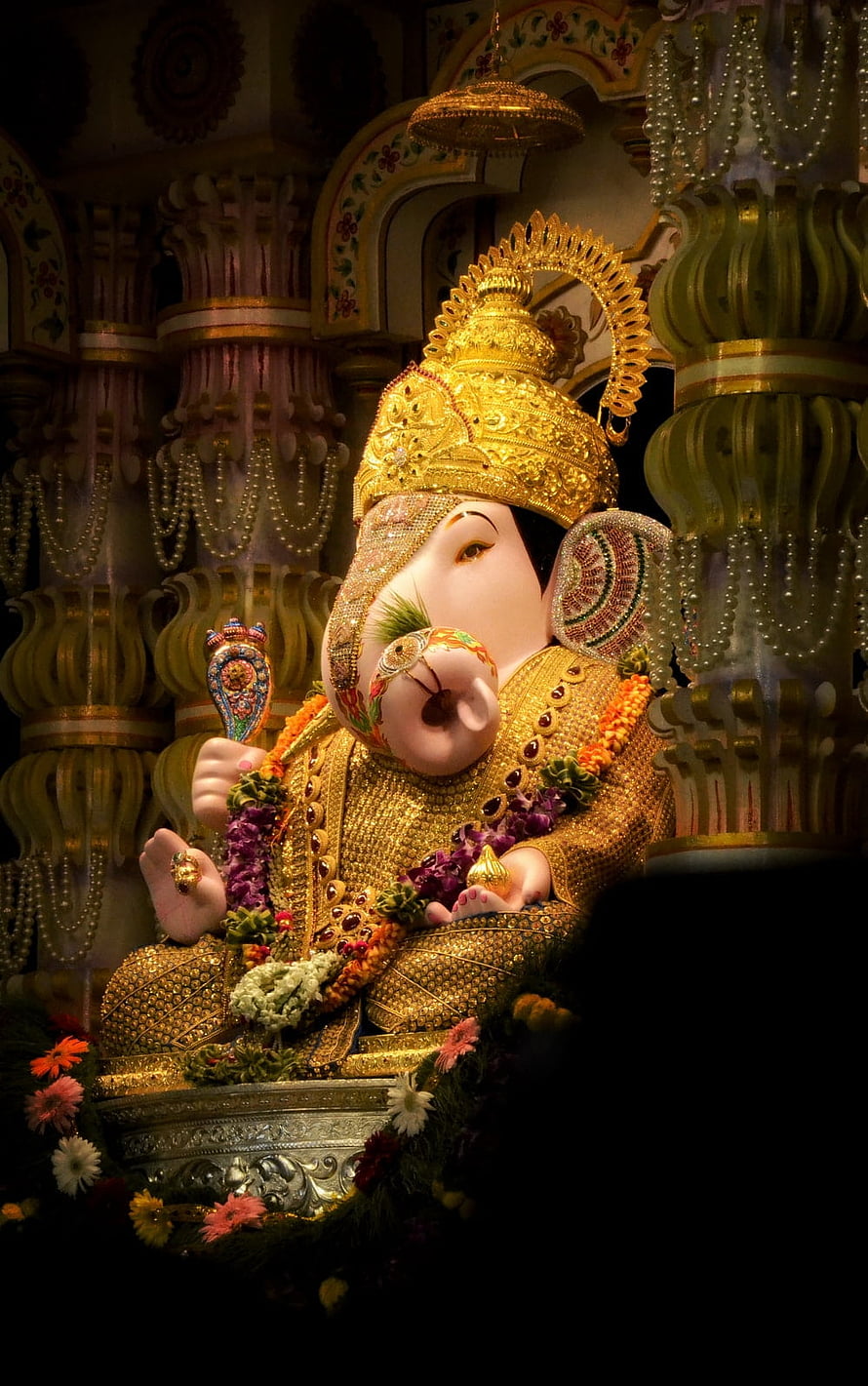 Ornate Golden Ganpati Murti Adorned with Marigold Garlands in a Decorated Temple Shrine HD phone wallpaper