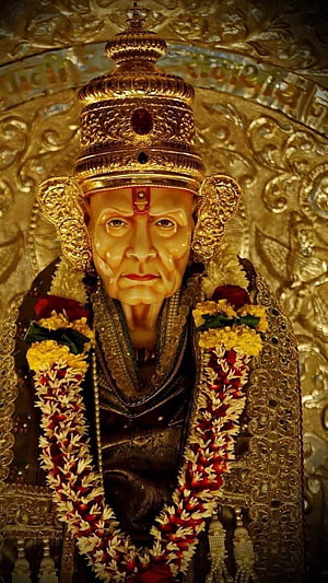 Ornate Golden Idol of Swami Samarth Adorned with Traditional Flower Garlands HD phone wallpaper