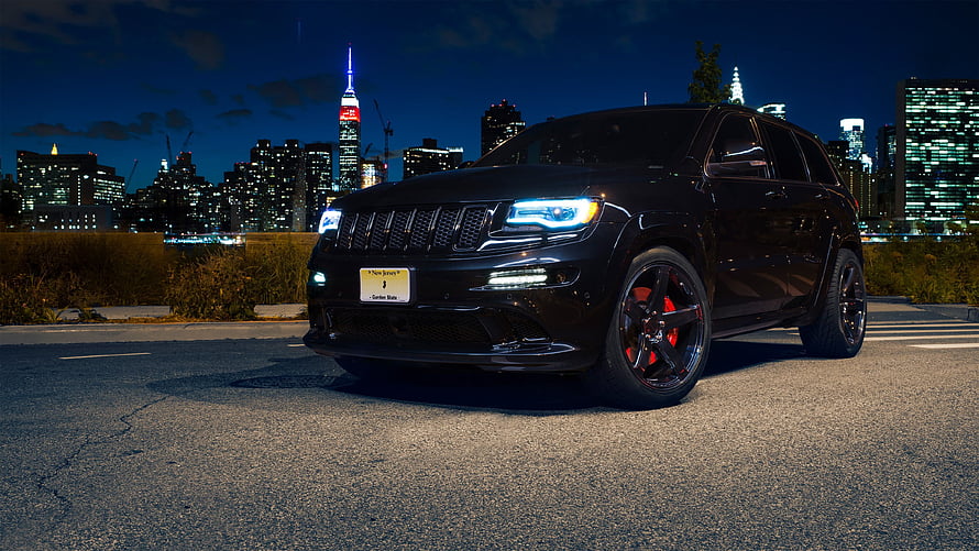 Black Jeep Grand Cherokee SRT with red brake calipers parked on a city street at night HD wallpaper