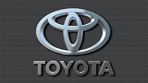 Sleek Chrome Toyota Emblem on Dark Carbon Fiber Textured Surface HD wallpaper
