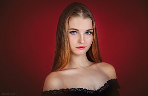 Studio Portrait of a Young Woman with Long Hair and Blue Eyes Against a Deep Red Background HD wallpaper
