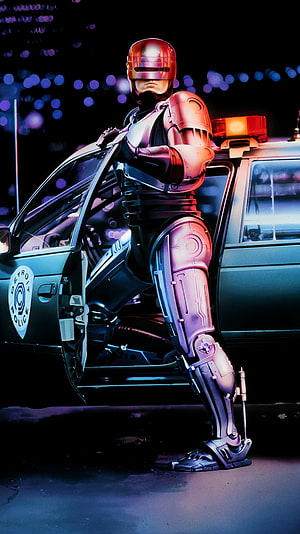 RoboCop Standing Beside a Detroit Police Car in a Neon-Lit Night Scene HD phone wallpaper