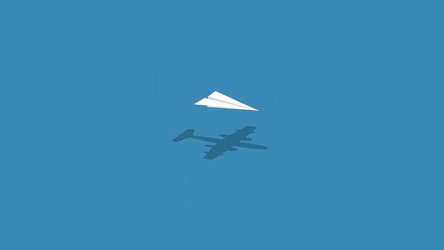 Minimalist Paper Airplane and Jet Shadow on Solid Blue Background HD wallpaper
