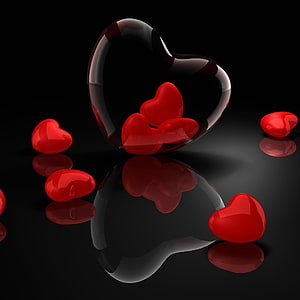 Glossy red hearts inside a transparent glass heart on a reflective black surface HD phone wallpaper