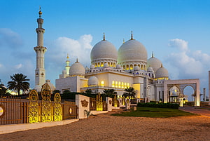 Sheikh Zayed Grand Mosque in Abu Dhabi at Dusk with Golden Illumination and Blue Sky HD wallpaper