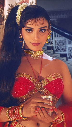 Swetha Menon in Traditional Red Attire with Gold Jewelry and Floral Hairpiece HD phone wallpaper