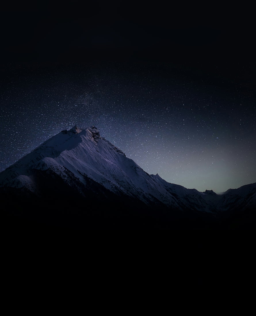 Snow-Capped Alpine Peak Under a Vast Starry Night Sky HD phone wallpaper
