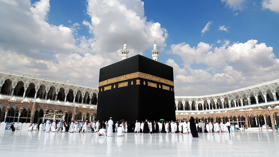 The Sacred Kaaba in Makkah Surrounded by Pilgrims Under a Bright Blue Sky HD wallpaper
