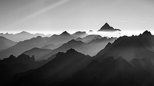 Monochromatic Mountain Range with Layered Peaks and Atmospheric Mist HD wallpaper