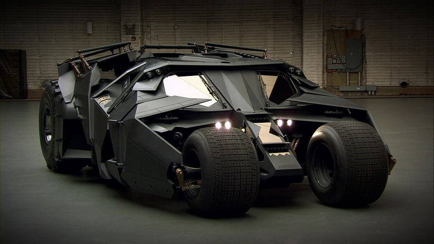 The Tumbler Batmobile from The Dark Knight in a dimly lit industrial garage HD wallpaper
