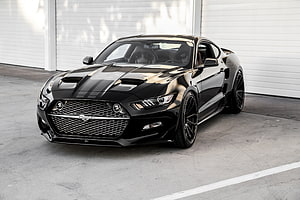 Black Ford Mustang GT with Hood Strakes Parked in a Concrete Garage HD wallpaper