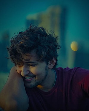 Darshan Raval in a moody teal-toned portrait with a warm smile and curly hair HD phone wallpaper