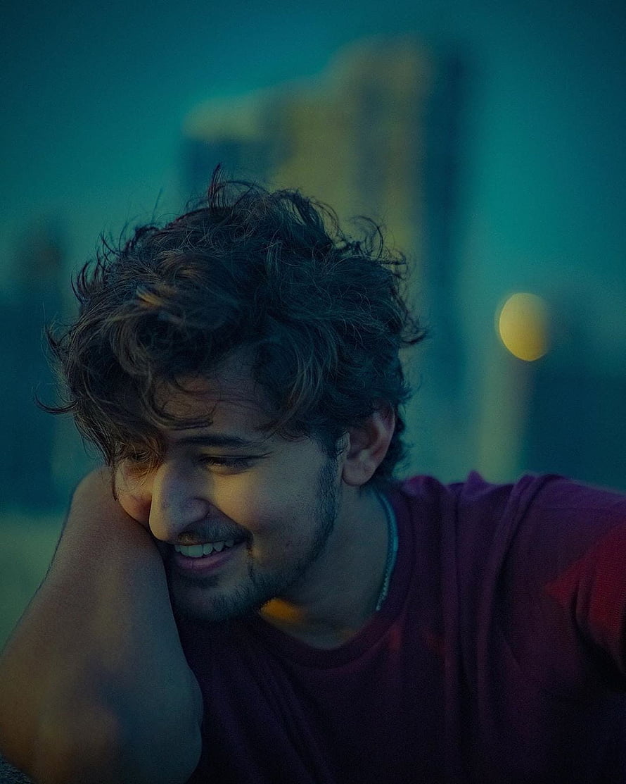 Darshan Raval in a moody teal-toned portrait with a warm smile and curly hair HD phone wallpaper