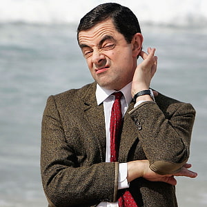Rowan Atkinson as Mr Bean making a comical face in a tweed jacket and red tie HD phone wallpaper