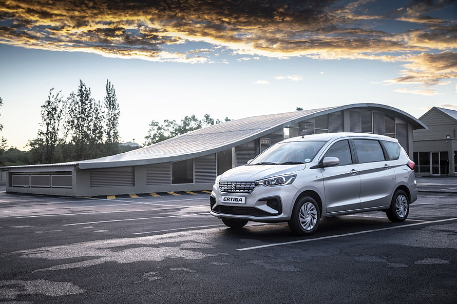 Silver Suzuki Ertiga MPV Parked in Modern Parking Lot at Sunset HD wallpaper