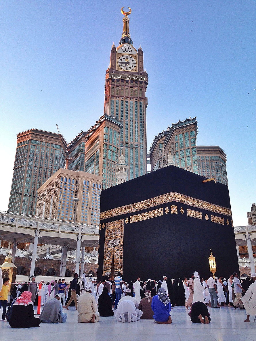 The Kaaba in Mecca with pilgrims praying and the Makkah Clock Tower in the background HD phone wallpaper