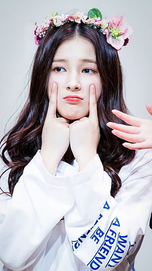 Nancy from MAMAMOO in a floral crown and white shirt with a playful pose HD phone wallpaper