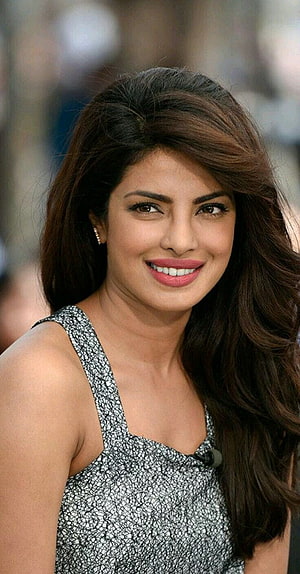 Priyanka Chopra smiling portrait in a patterned sleeveless top with long wavy hair HD phone wallpaper