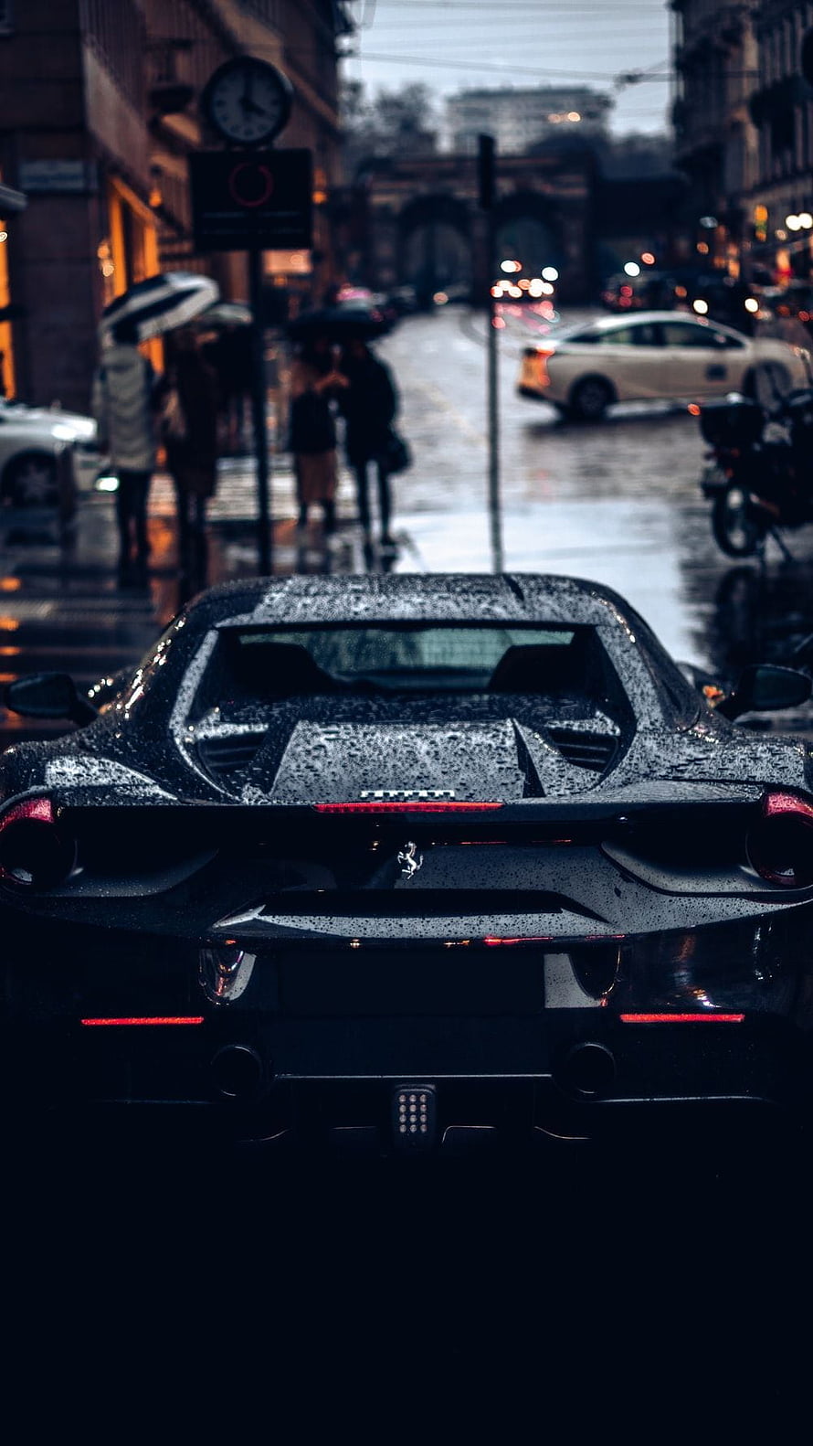 Rear View of a Black Ferrari Super Car Parked on a Rainy City Street at Dusk HD phone wallpaper