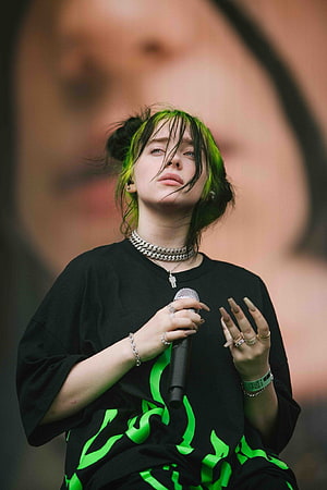 Billie Eilish performing live on stage with vibrant green hair and black graphic tee HD phone wallpaper