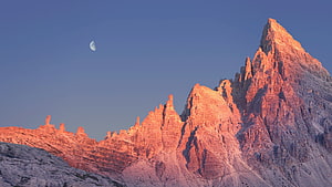 Alpine Mountain Peaks Bathed in Golden Sunset Light with Crescent Moon HD wallpaper