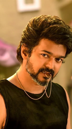 Vijay in a rugged black sleeveless top with a gold chain and a confident, intense expression HD phone wallpaper
