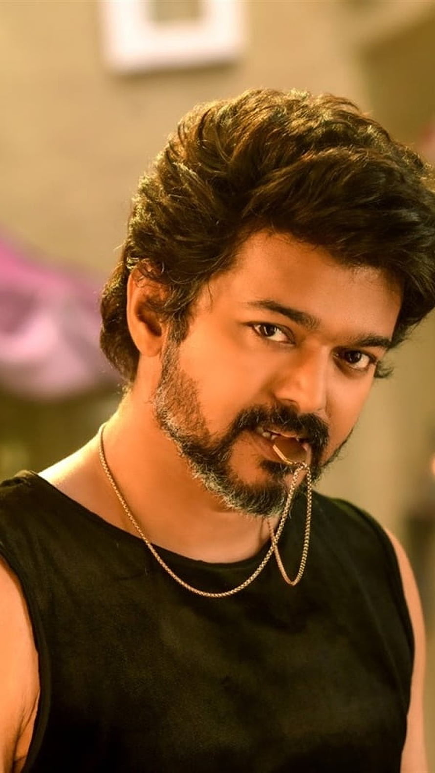 Vijay in a rugged black sleeveless top with a gold chain and a confident, intense expression HD phone wallpaper