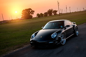 Black Porsche 911 Turbo 997 parked on a rural road at golden hour sunset HD wallpaper