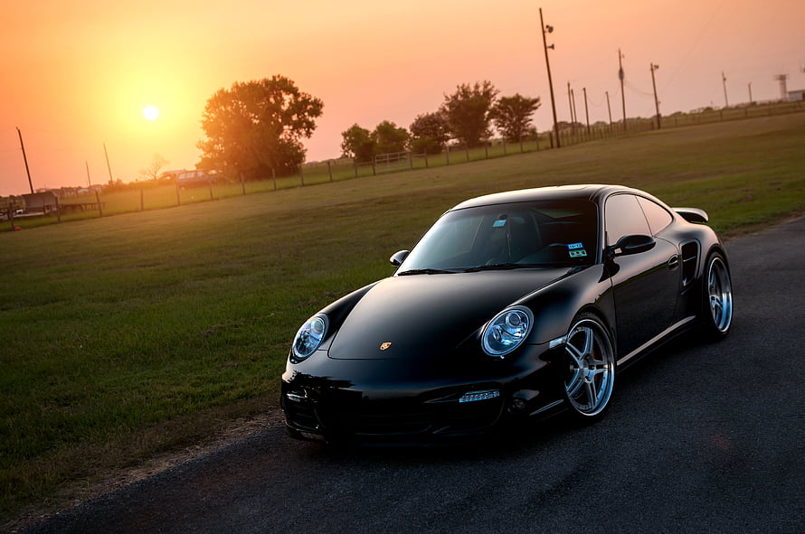 Black Porsche 911 Turbo 997 parked on a rural road at golden hour sunset HD wallpaper