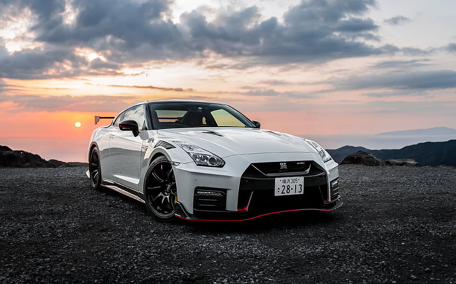 White Nissan GT-R Nismo Coupe Parked on Gravel at Sunset with Dramatic Clouds HD wallpaper