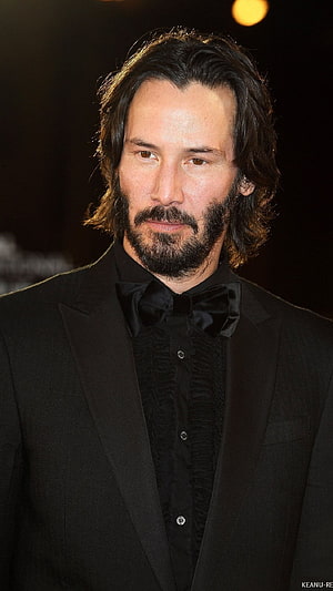 Keanu Reeves in a Black Tuxedo with Bow Tie and Full Beard at a Formal Event HD phone wallpaper