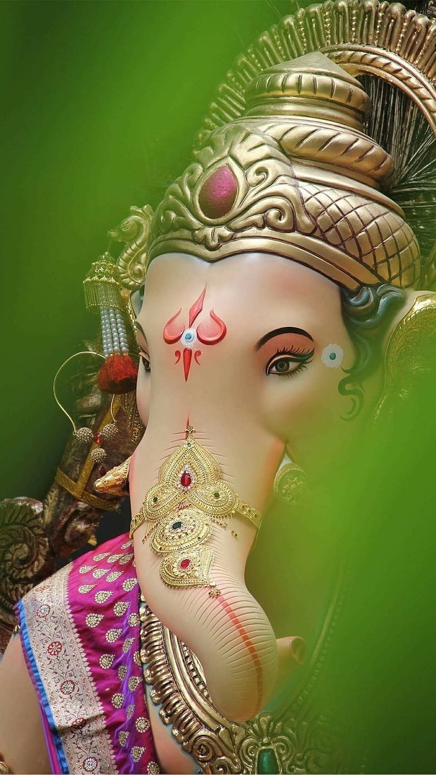 Ornate Ganesha Murti With Gold Crown And Intricate Jewelry Against Green Background HD phone wallpaper