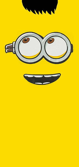 Minion Face Close-Up with Goggles and Big Smile on Bright Yellow Background HD phone wallpaper