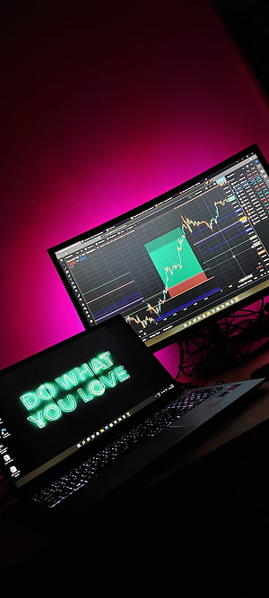 Trading Desk Setup with Stock Charts and Neon Motivational Quote on Laptop HD phone wallpaper