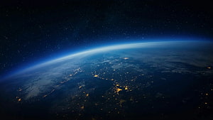 Earth at Night From Orbit: City Lights and Atmospheric Glow Against the Starry Cosmos HD wallpaper