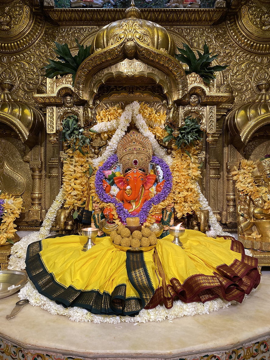 Siddhivinayak Ganesh Murti Adorned With Marigold Garlands And Yellow Silk Cloth HD phone wallpaper