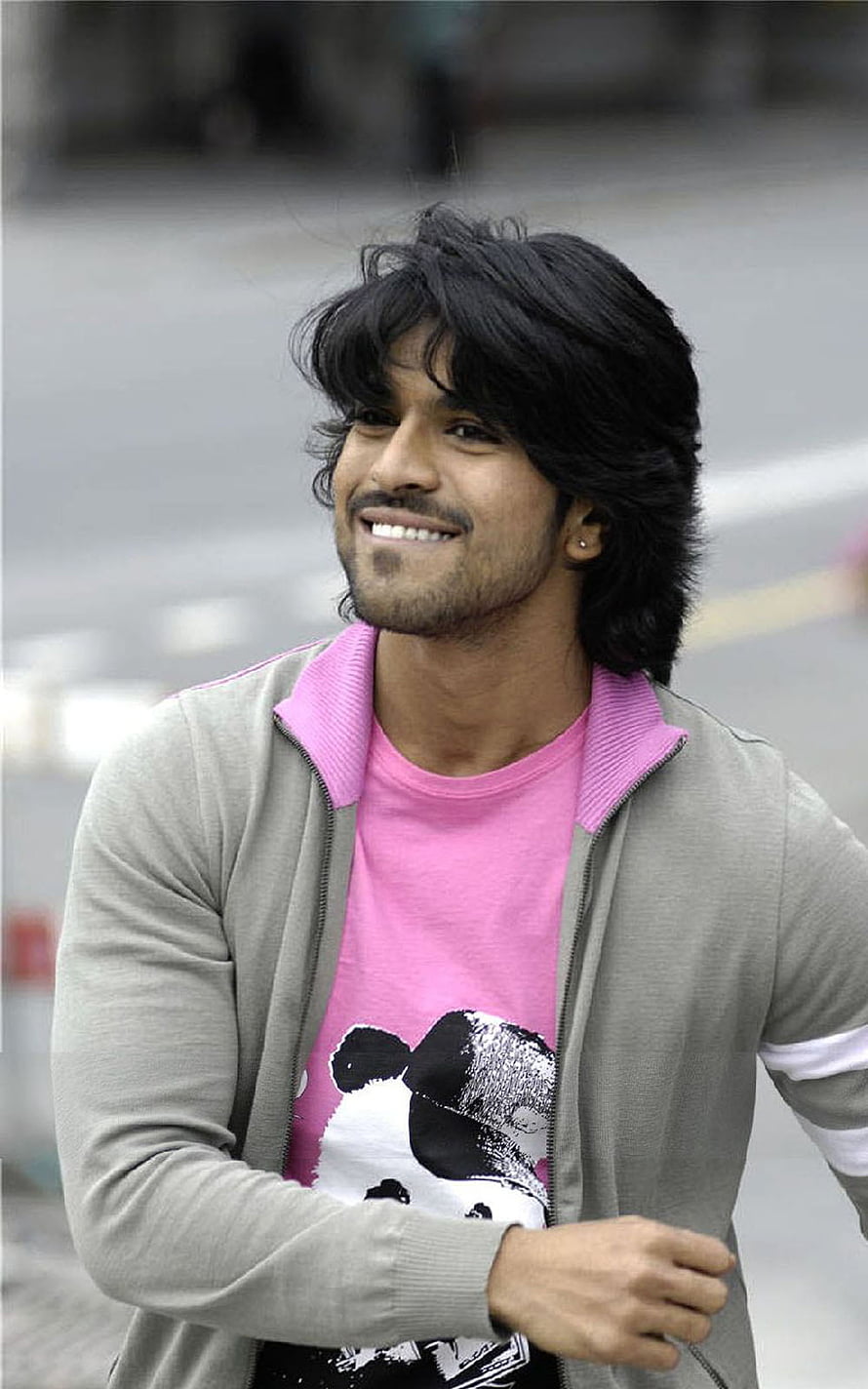 Ram Charan Teja in casual pink t-shirt and grey cardigan with a warm smile HD phone wallpaper