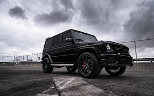 Black Brabus G63 G-Wagon SUV on Concrete Rooftop Under Stormy Sky HD wallpaper