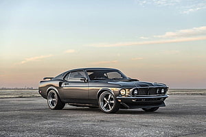 Classic Black Ford Mustang Fastback on Open Tarmac at Golden Hour HD wallpaper