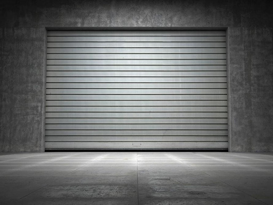 Minimalist Concrete Garage Interior With Closed Metal Roller Door HD wallpaper