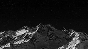 Monochrome Snow-Capped Mountain Range Under a Starry Night Sky HD wallpaper