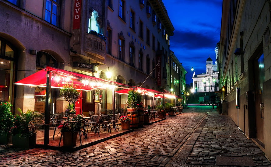 Helsinki Old Town Cobblestone Alley at Dusk with Restaurant Terrace and Church Spire HD wallpaper