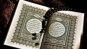 Ornate Open Holy Quran with Prayer Beads and Intricate Islamic Calligraphy HD wallpaper