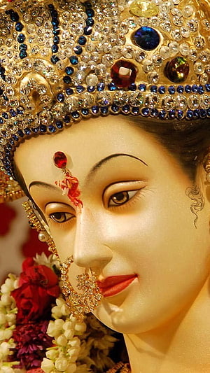 Close-up of Durga Devi idol adorned with jeweled crown and floral garlands HD phone wallpaper