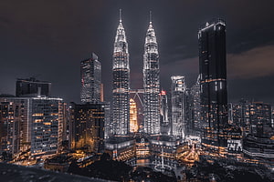 Petronas Twin Towers Illuminated Against a Dark Night Sky in Kuala Lumpur Cityscape HD wallpaper