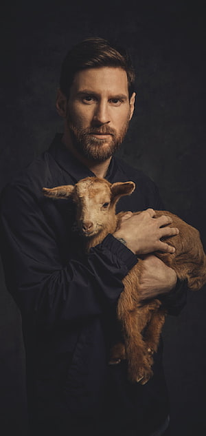 Lionel Messi Portrait Holding a Young Lamb in Dark Studio Setting HD phone wallpaper