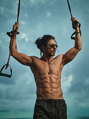 Shah Rukh Khan as Pathan in a shirtless outdoor workout scene with resistance straps HD phone wallpaper