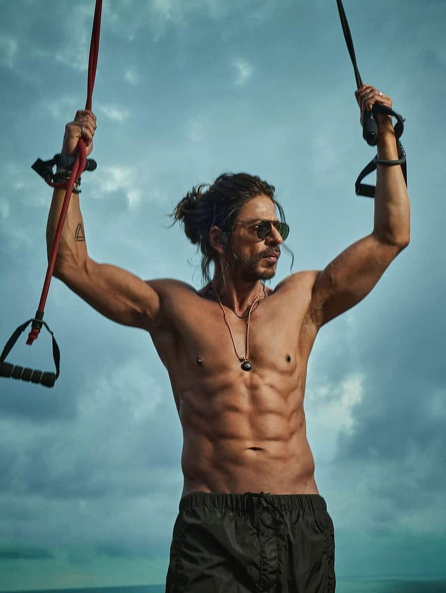 Shah Rukh Khan as Pathan in a shirtless outdoor workout scene with resistance straps HD phone wallpaper