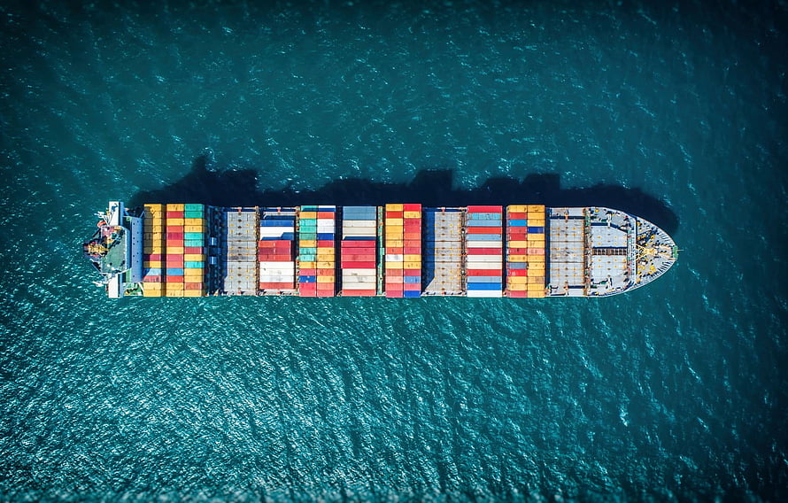 Aerial View of a Colorful Container Ship Sailing Across Deep Blue Ocean Waters HD wallpaper