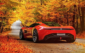 Red Aston Martin Supercar Parked on a Winding Road Surrounded by Vibrant Autumn Foliage HD wallpaper